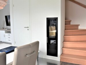 A modern interior with a desk, chair, and a built-in black entertainment unit. - House No. 16, Deichgraf (Wangerland)