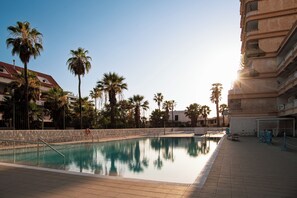 A swimming pool with a clear view of the surrounding buildings and palm trees. - DANICO PLAYA HONDA 51/C (Playa de las Américas)