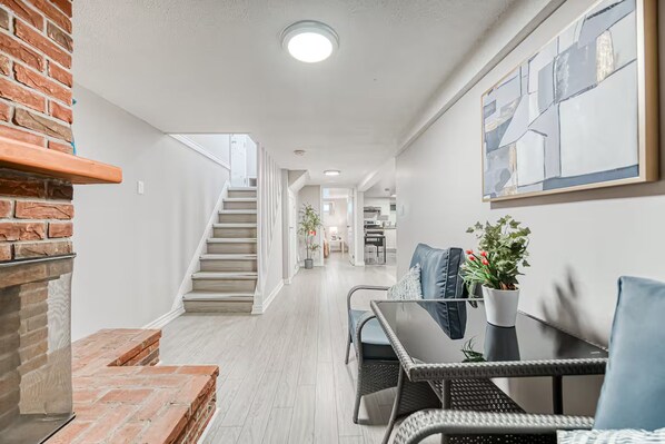 Ein modernes Interieur mit Treppe, Essbereich und Küche im Hintergrund.