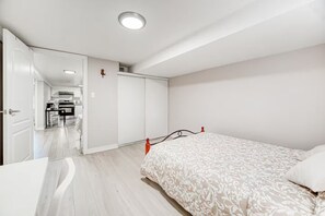 Ein Schlafzimmer mit einem Bett, einem Nachttisch und einer Tür zu einem Badezimmer.