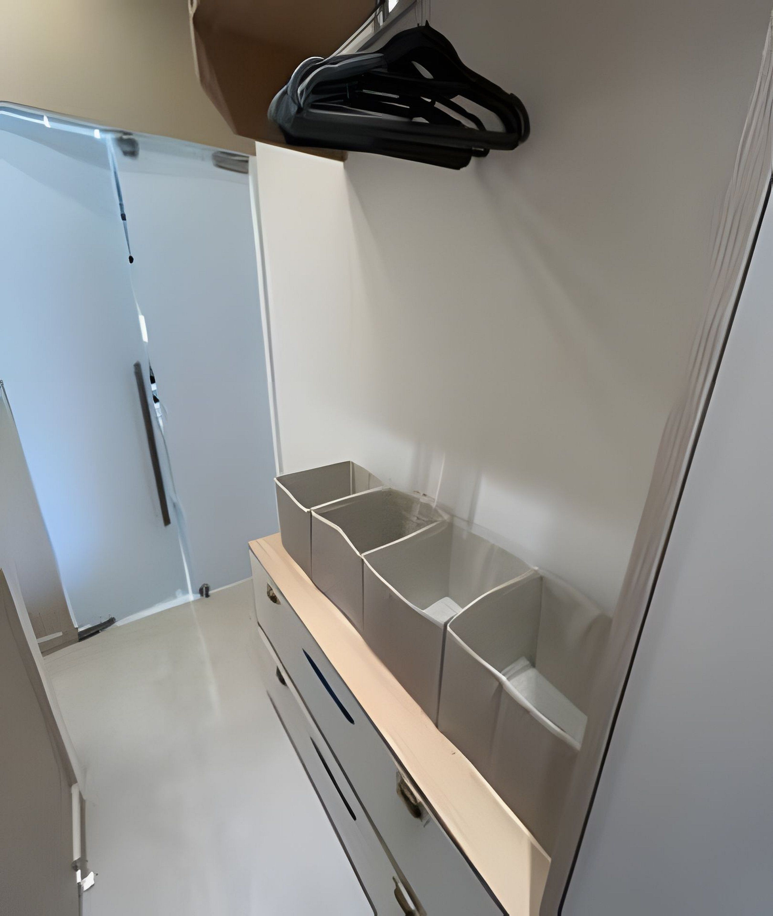 A walk-in closet with open shelving and a hanging rod.