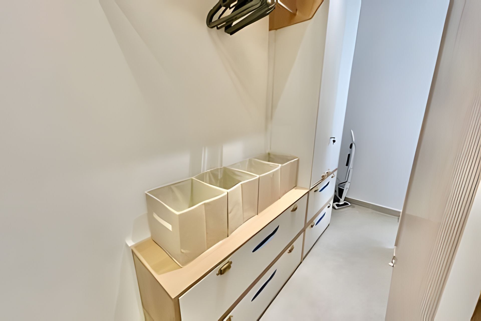 A clean, minimalist bathroom with a white vanity, a mirror, and a toilet.