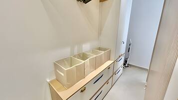 A clean, minimalist bathroom with a white vanity, a mirror, and a toilet.