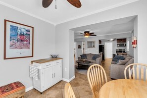 A spacious living area with a dining table, chairs, a sofa, and a ceiling fan. - Spacious 3BR Seaside Park Getaway Near the Beach (Seaside Park)