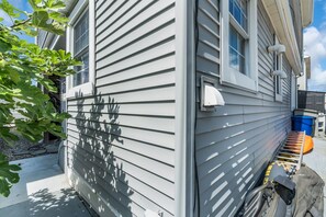 A house with horizontal siding, a visible window, and a ladder leaning against the side. - Spacious 3BR Seaside Park Getaway Near the Beach (Seaside Park)