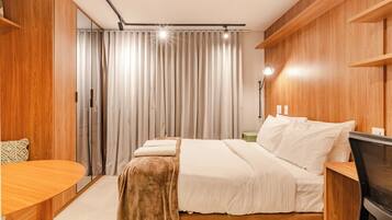 Een moderne slaapkamer met een groot bed, een houten bureau en een televisie.