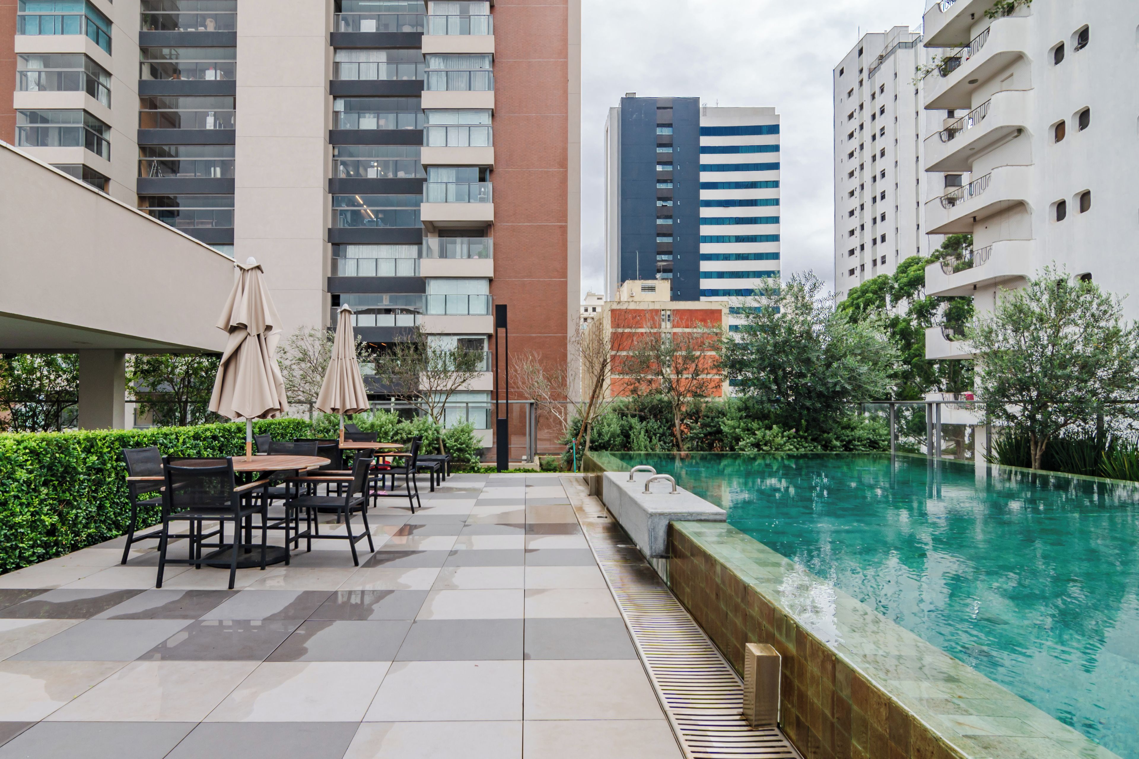 A rooftop pool area with outdoor seating and a view of surrounding buildings.