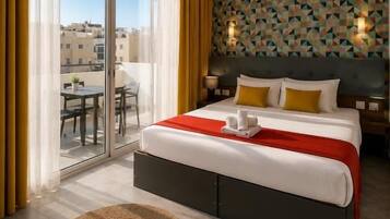 Quarto de hotel com uma cama grande, vista por uma porta deslizante para área externa e parede com padrão.