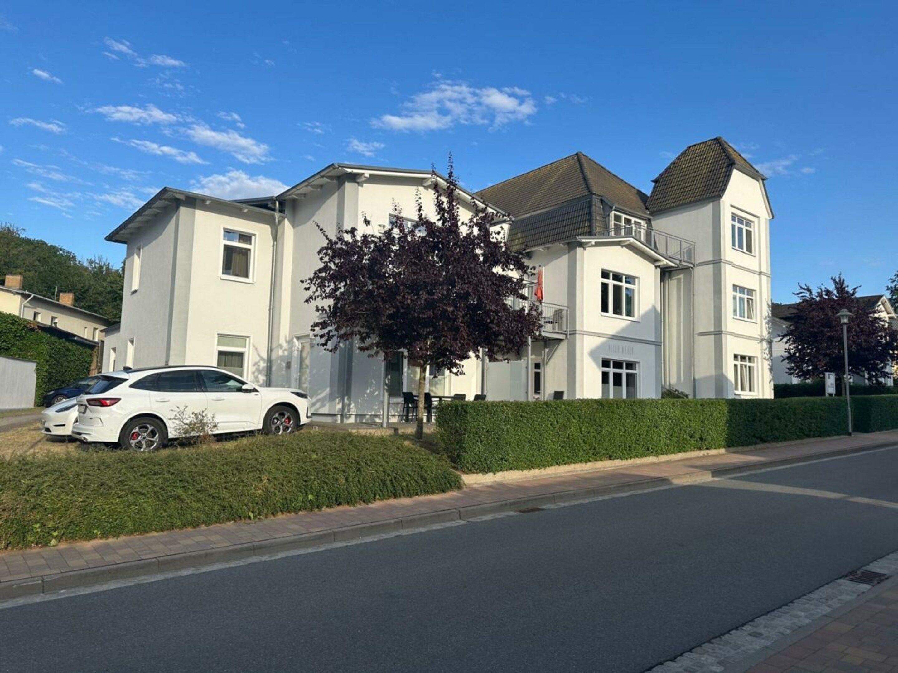 Een woongebouw met een twee verdiepingen, een plat dak en een zichtbare garage.