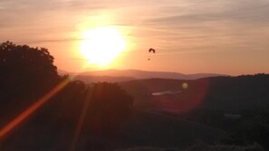A sunset with a silhouette of trees and a distant landscape. - Holiday Home 'Mare E Monti' with Mountain View, Private Pool, and Air Conditioning (Petriolo)