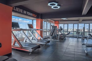 A gym with treadmills, weight machines, and a motivational quote on the wall. - 2-bedroom with Extra Room in Nairobi,Westlands Near Sarit, with pool, gym, cafes (Nairobi)