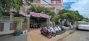 Un edificio con un cartel que dice 'KHMER HOUSE KAMPOT BOUTIQUE' y varias motocicletas estacionadas.