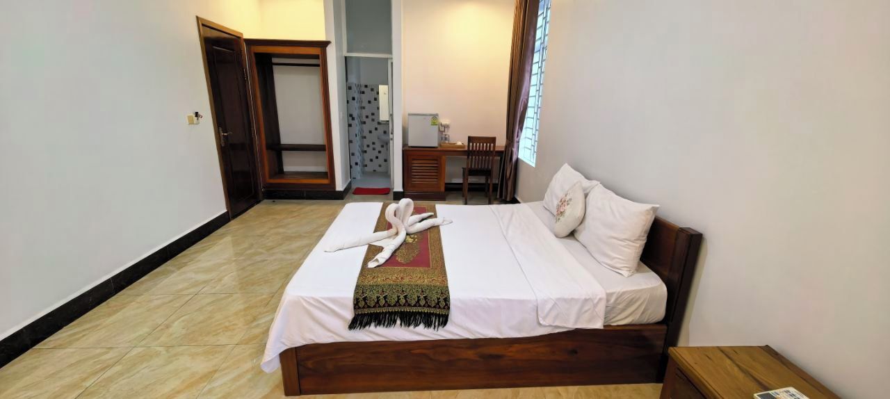 Una habitación de hotel con cama, escritorio y silla.