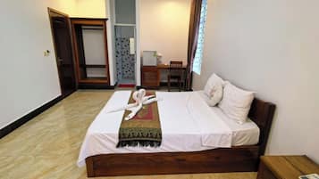 Una habitación de hotel con cama, escritorio y silla.