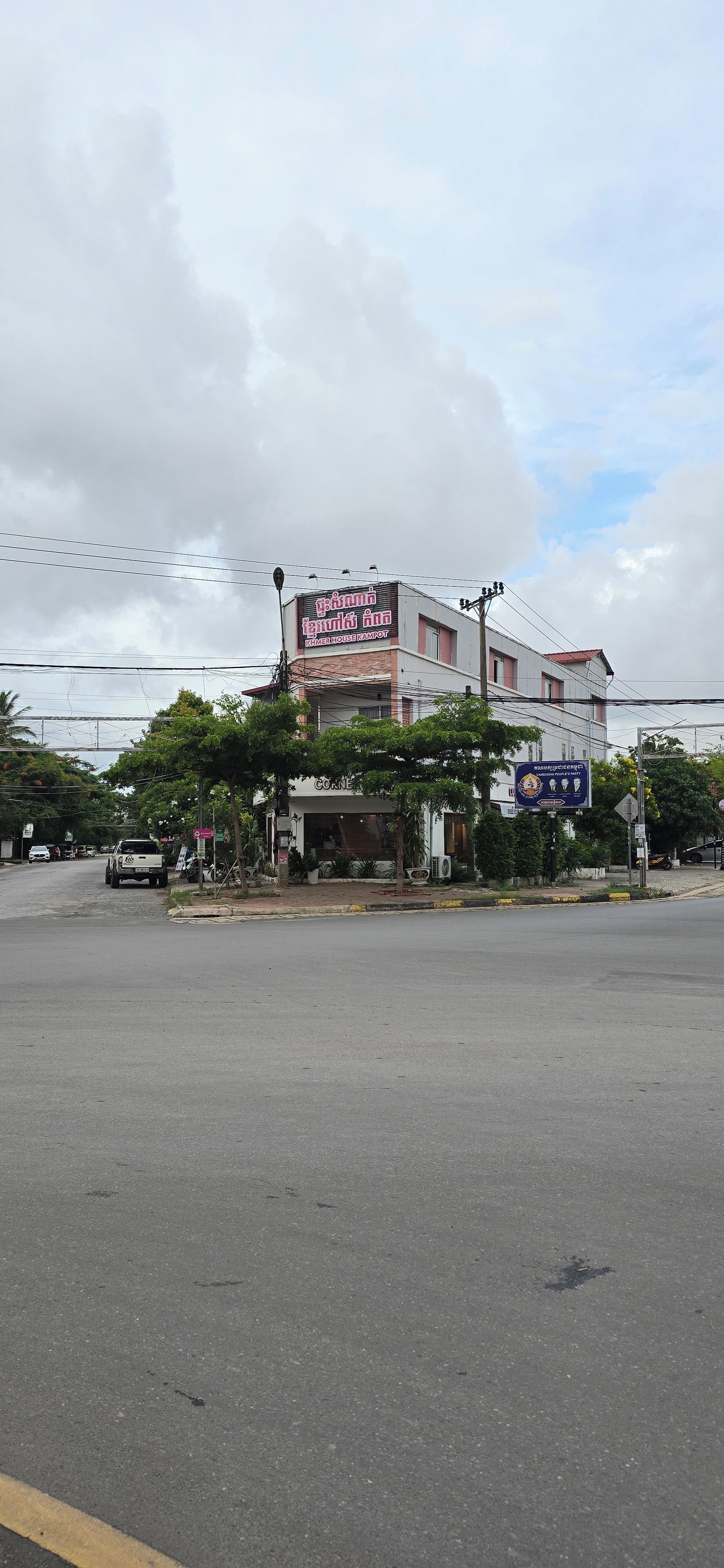 A building with a sign for 'KHMER HOUSE KAMPOT' and another sign for 'CAMBODIAN PEOPLE'S PARTY'.