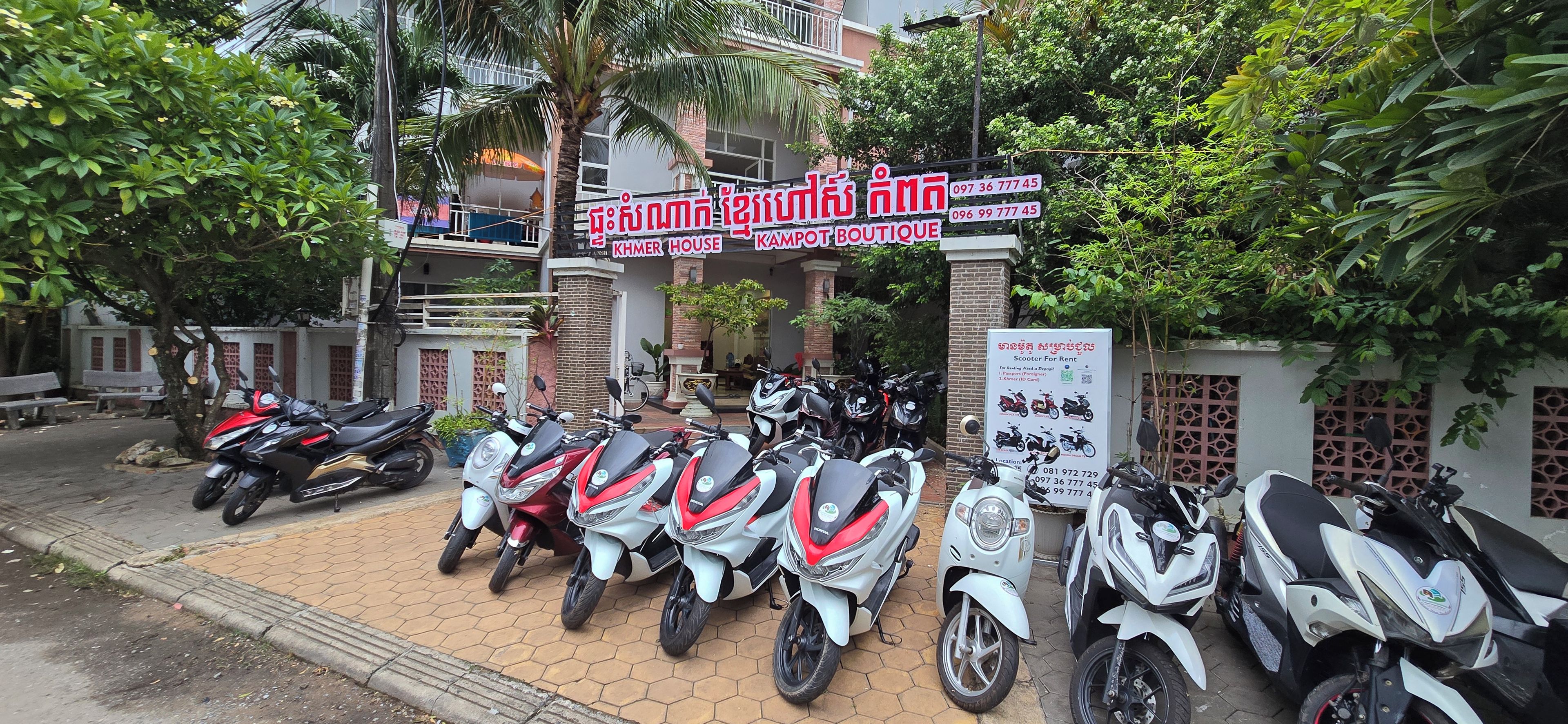 A building with a sign for 'Khem House Boutique' and a scooter rental sign.