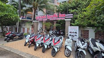 A building with a sign for 'Khem House Boutique' and a scooter rental sign.