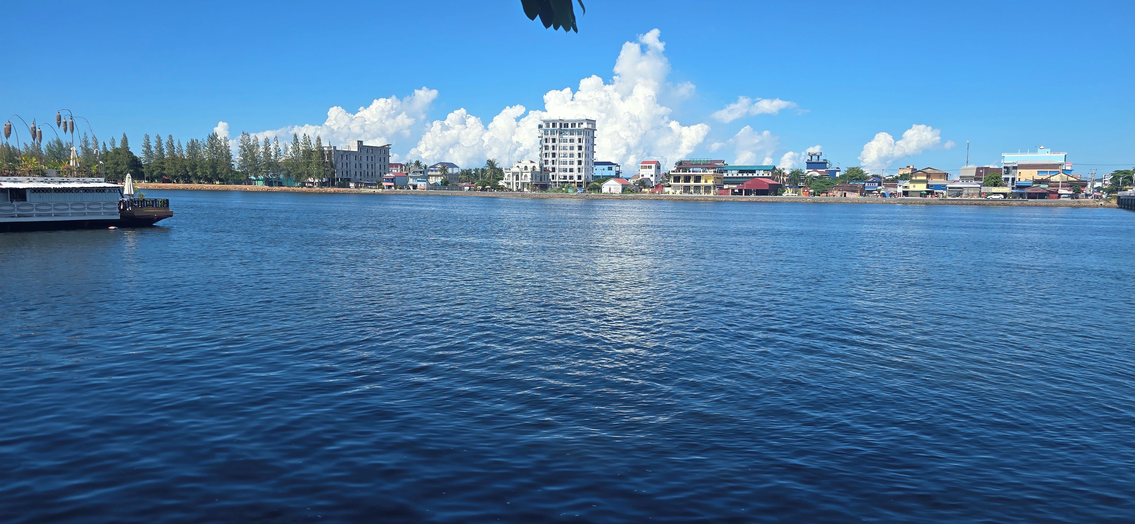 A waterfront view with a large building and a boat.