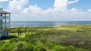 A multi-story building with a view of a coastal landscape, including a beach and marshy areas. - Sweeping bay views/community amenities! (Galveston)