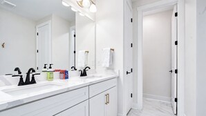 A modern bathroom with a white vanity, two sinks, and a large mirror. - The Oak Grove, 3BR by Velvet Ditch Villas (Oxford)