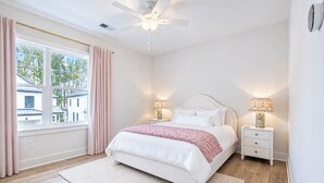 A bedroom with a bed, bedside tables, a ceiling fan, and a window with curtains. - The Oak Grove, 3BR by Velvet Ditch Villas (Oxford)