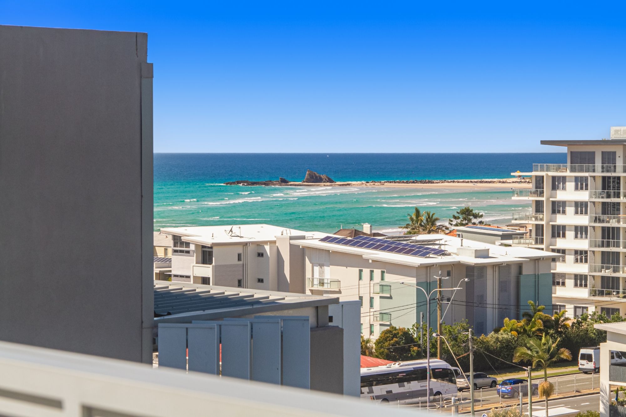 En kustvy med byggnader, en strand och havet.