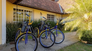 Edificio amarillo con techo de tejas y una bicicleta estacionada adelante.