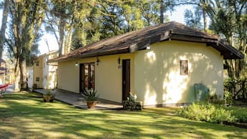 A single-story building with a tiled roof, a front door, and a small porch area.