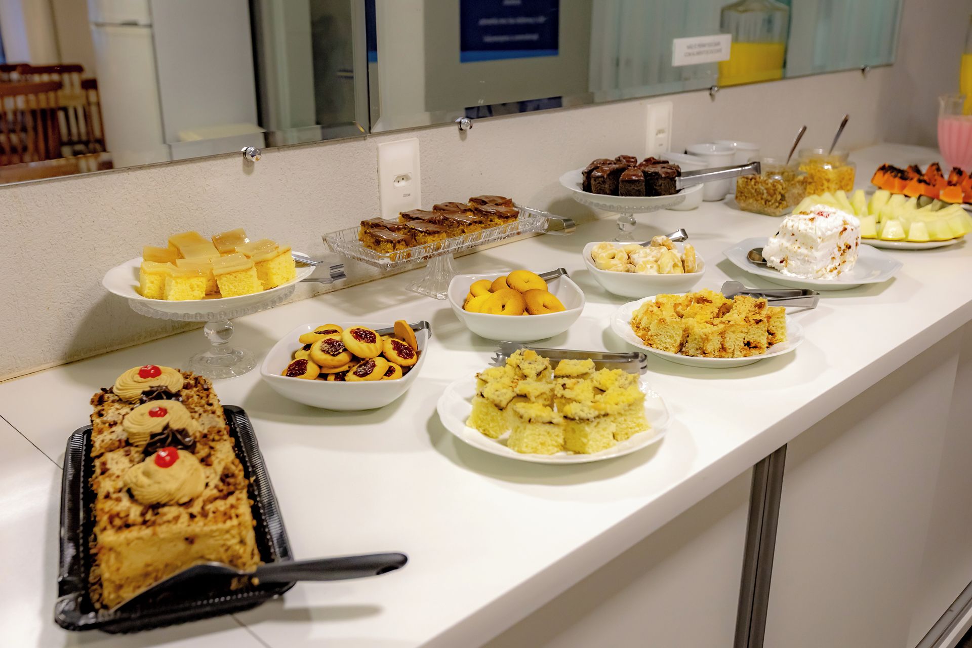 Un buffet proposant une variété de desserts, notamment des gâteaux, des biscuits et des fruits.