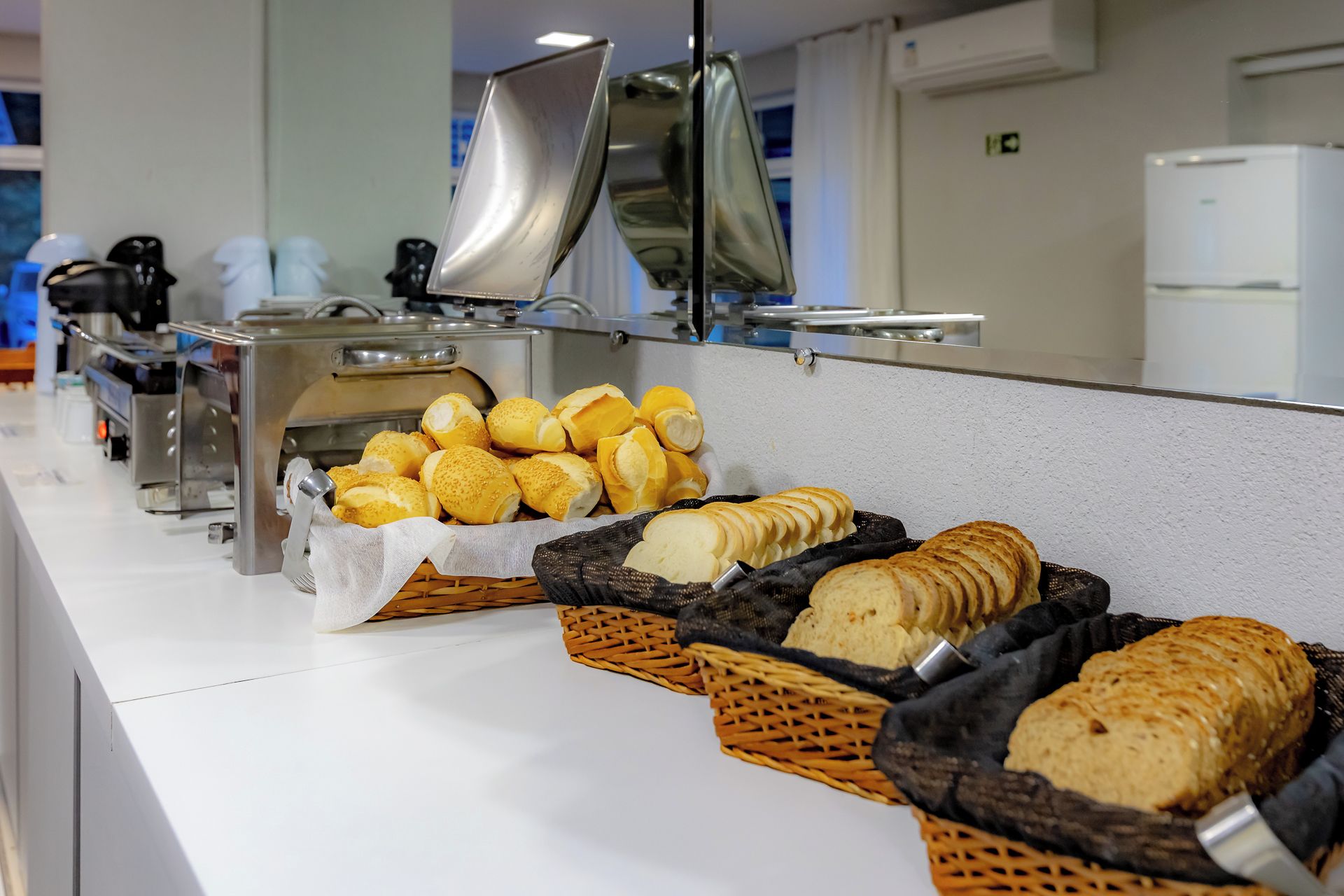 Un mostrador de buffet con panes y pasteles varios.