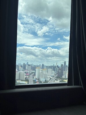 Vista de un paisaje urbano a través de una ventana con cortinas.