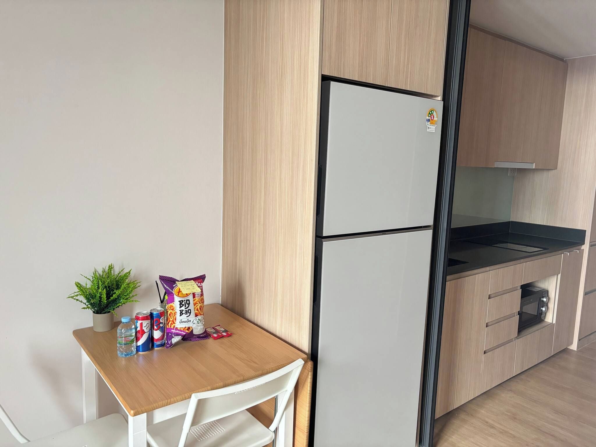 A compact kitchen with a refrigerator, a microwave, and a small countertop.
