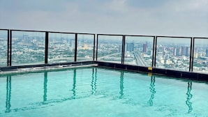 Une piscine à débordement située sur le toit, offrant une vue panoramique sur la ville.