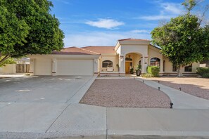 A two-story house with a garage, a driveway, and a landscaped front yard. - New Luxe 5BR Resort | Pool, Pickleball | Theater (Mesa)