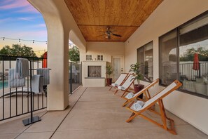 A covered outdoor area with a ceiling fan, a pool, and lounge chairs. - New Luxe 5BR Resort | Pool, Pickleball | Theater (Mesa)