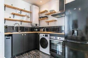 Eine moderne Küche mit integrierten Geräten, Holzböden und einem schwarz-weißen Fliesenboden.