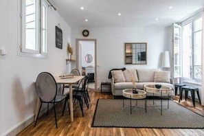 Ein modernes Wohnzimmer mit einer Couch, einem Couchtisch und einem Essbereich.