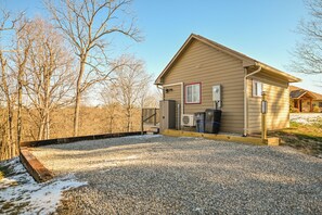 A single-story house with a gravel driveway and a wooden deck. - "Tiny Tranquility" The Luxury Tiny House (Athens)