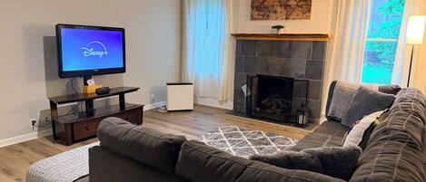Un salon avec une télévision, une cheminée et un canapé.