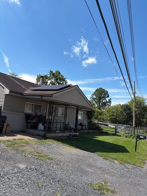 A residential house with a front porch, a chimney, and a small garden area. - 3-bedroom house in charming Walnutport with AC for relaxing stays (Walnutport)