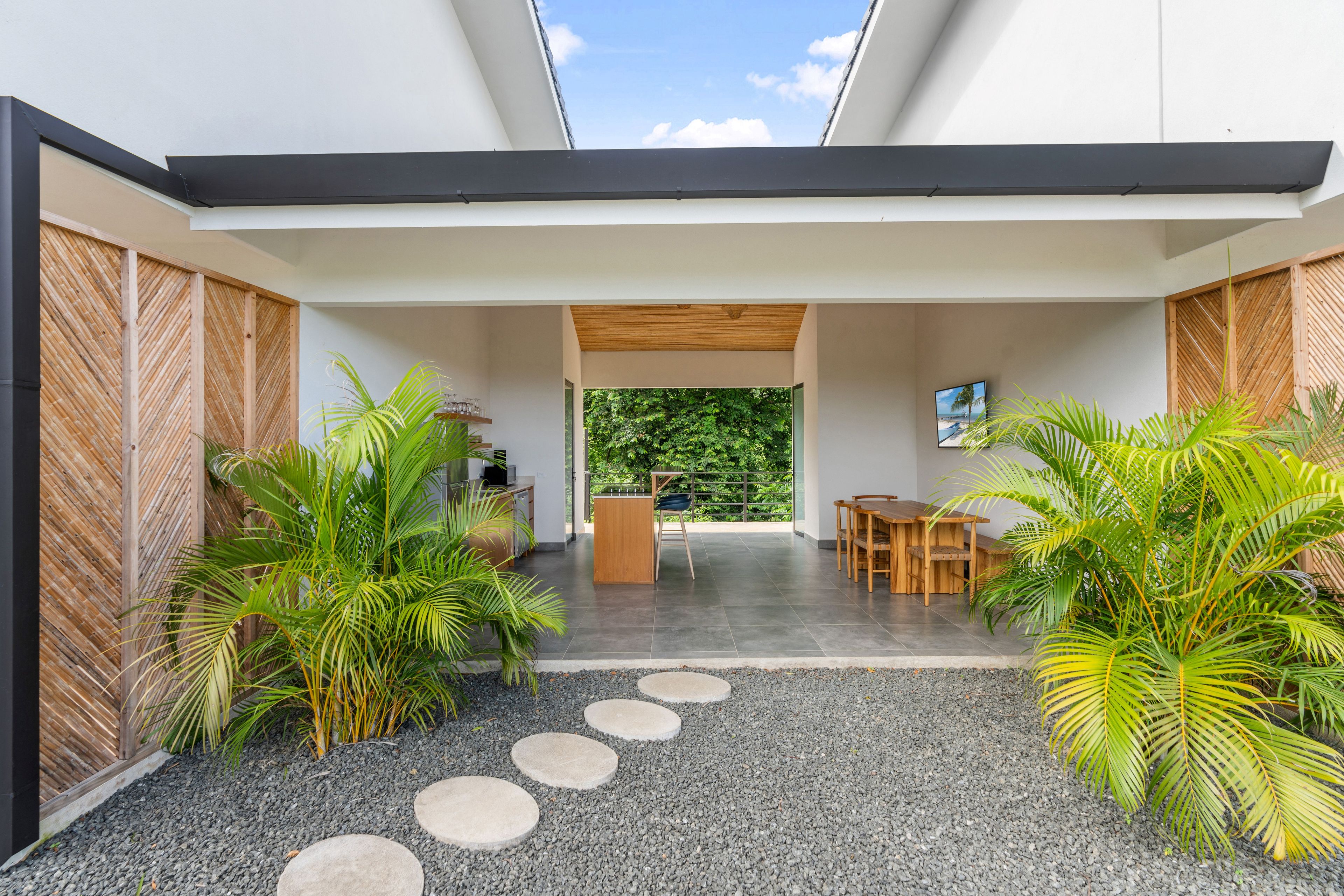 Un interior moderno con comedor, cocina y vistas al exterior.
