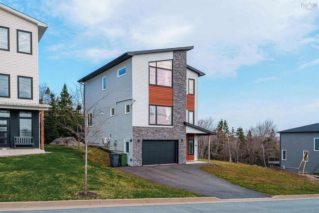 A modern two-story residential building with a garage, a small front yard, and a neighboring house.