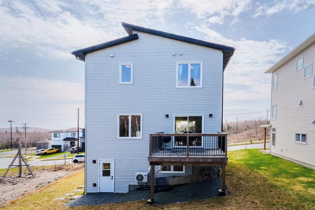 A two-story residential building with a balcony, a garage, and a driveway.