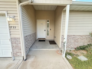 A house entrance with a number '1733' on the wall, a door, and a small porch area. - Bright 3 Bedroom 2 Bath Home + 2 Car Garage + Fast Wifi (Twin Falls)