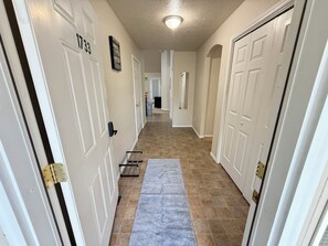 A hallway with white doors, a grey carpet, and a tiled floor. - Bright 3 Bedroom 2 Bath Home + 2 Car Garage + Fast Wifi (Twin Falls)