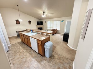 A spacious kitchen with a central island, a dishwasher, and a trash can. - Bright 3 Bedroom 2 Bath Home + 2 Car Garage + Fast Wifi (Twin Falls)