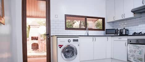 A compact kitchen with a built-in washer, a microwave, and a stove.