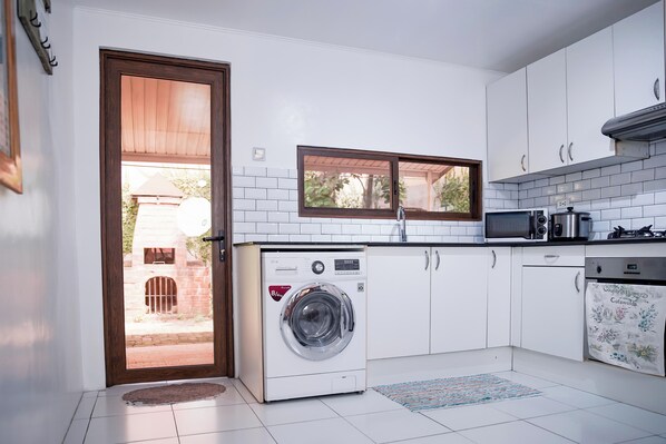 A compact kitchen with a built-in washer, a microwave, and a stove.