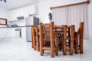 A kitchen with white cabinets, a microwave, a stove, and a refrigerator.