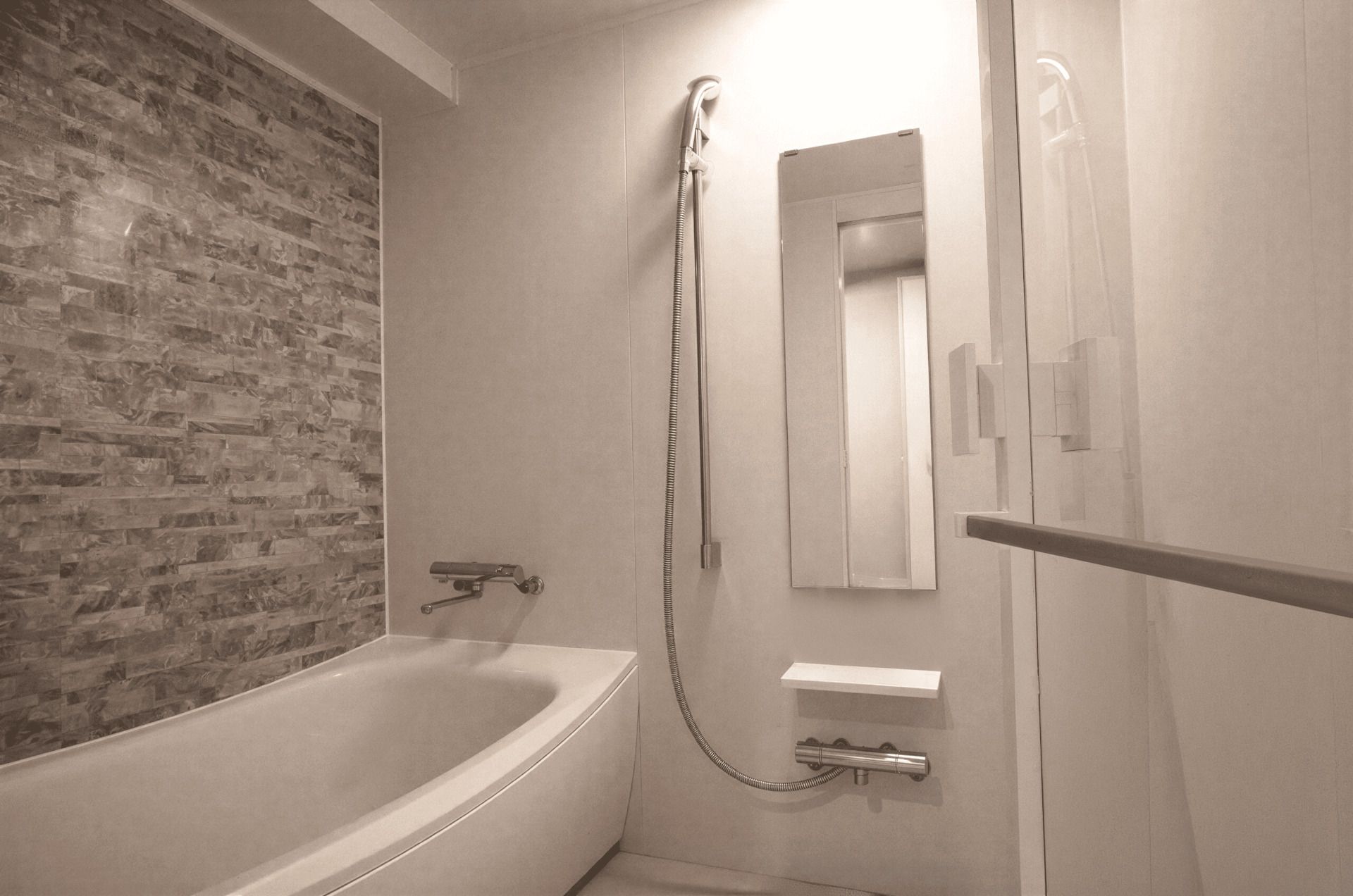 A bathroom with a bathtub, a shower, and a mirror.